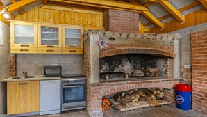 Una cocina con armarios de madera, una estufa y una chimenea de ladrillo.