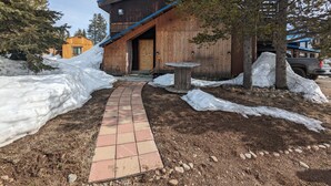A wooden building with a brick pathway leading to the entrance. - Cozy cabin loft with a giant soaking tub just 30 minutes from Yellowstone (Island Park)