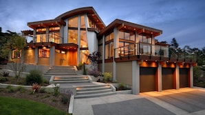 A modern two-story house with large windows, a curved roof, and a well-lit entrance. - Madrid (Madrid)