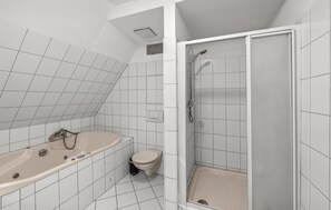 Une salle de bain avec une baignoire, des toilettes et une douche.