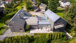 An aerial view of a modern residential area with a mix of detached houses and a large building with a glass facade and a sloped roof. - Pet friendly home in ålesund (Ålesund)
