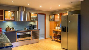 A modern kitchen with built-in appliances, wooden cabinetry, and a stainless steel refrigerator. - Pet friendly home in ålesund (Ålesund)