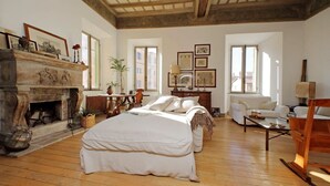 Una habitación amplia con chimenea, cama, sofá y una mesa de comedor.