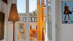 Quarto com janela para um pátio, uma luminária e um quadro na parede.