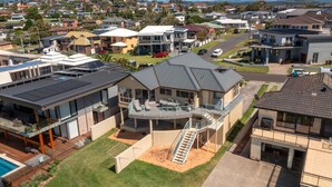 A modern two-story house with a balcony, a swimming pool, and a well-maintained lawn. - Dellwood – absolute beachfront on Jones Beach (Kiama Downs)