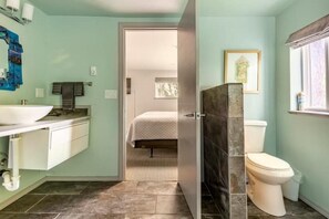 Un baño con lavamanos blanco, inodoro y zona de ducha.