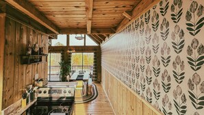Un intérieur en bois comprenant un coin cuisine, une table à manger et une vue sur l’extérieur.