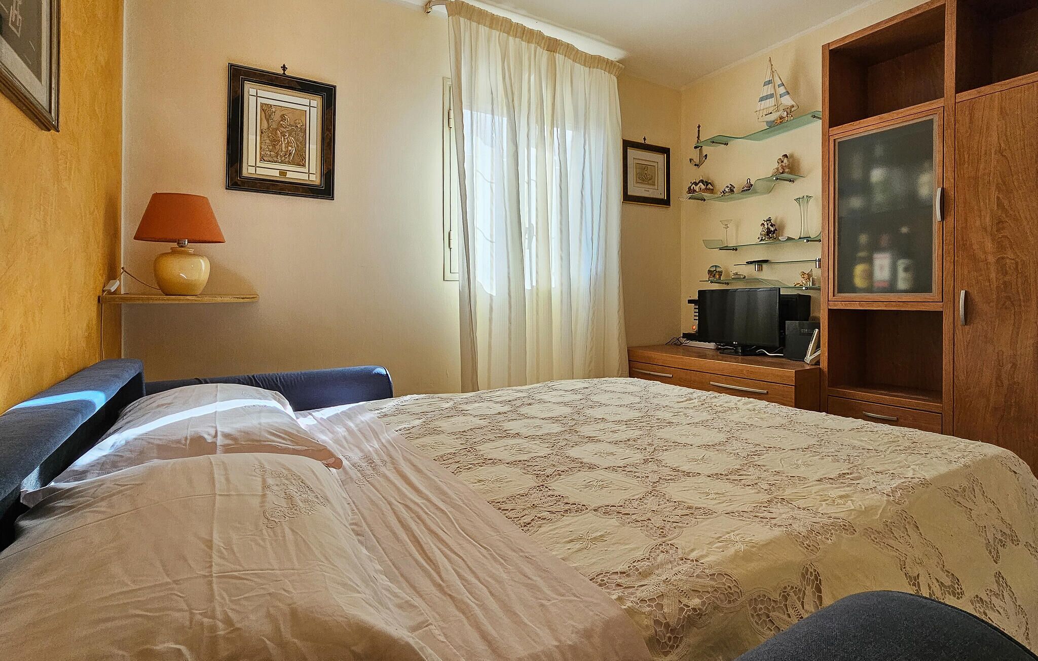 Une chambre d’hôtel comprenant un lit, un bureau, une télévision et une armoire.