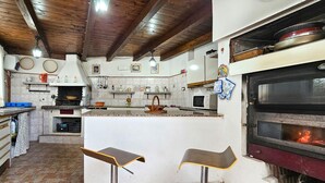 A kitchen with a central island, two bar stools, a built-in oven, and various kitchen utensils and appliances. - 2 bedroom awesome home in Altavilla Milicia (Altavilla Milicia)