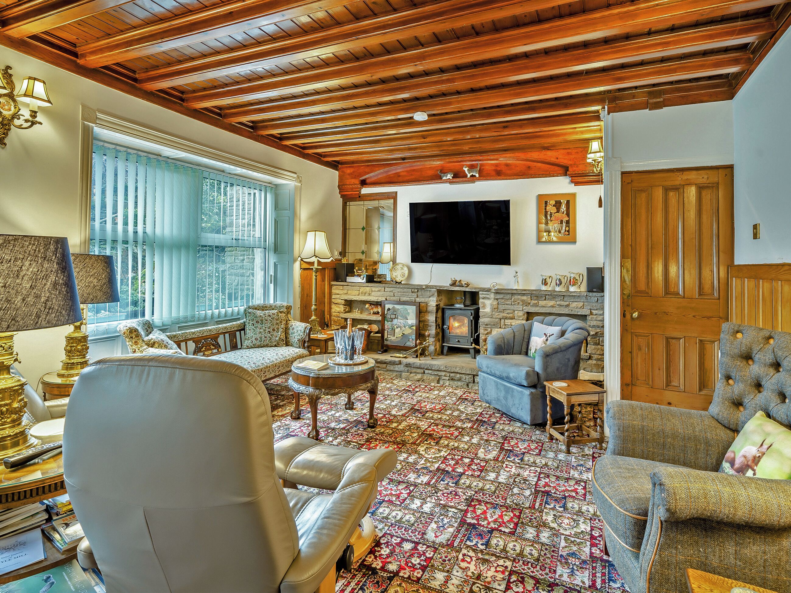 A living room with a fireplace, a television, and a patterned rug.