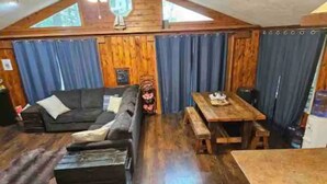 A cozy living area with a sofa, a wooden table, and a bench. - Beautiful 2BR+Loft Cottage with amazing views!

 (Beaverton)