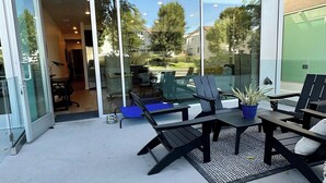 An outdoor patio with glass doors leading to an interior space, featuring outdoor seating and a potted plant. - Like a hotel but better! Pet friendly, exclusive patio, near beach, free parking (San Diego)
