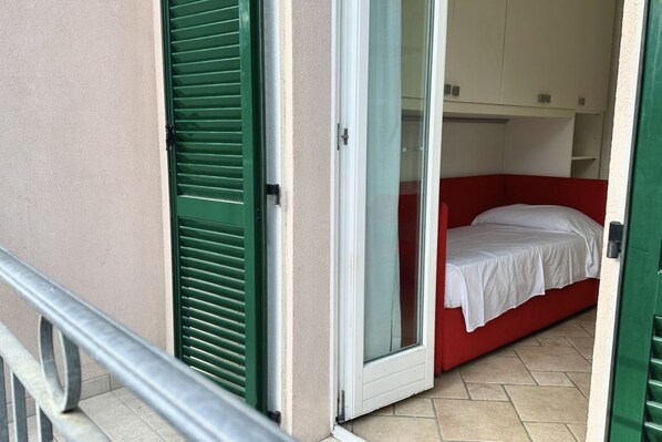 A room with a bed, a sliding door, and a small closet.