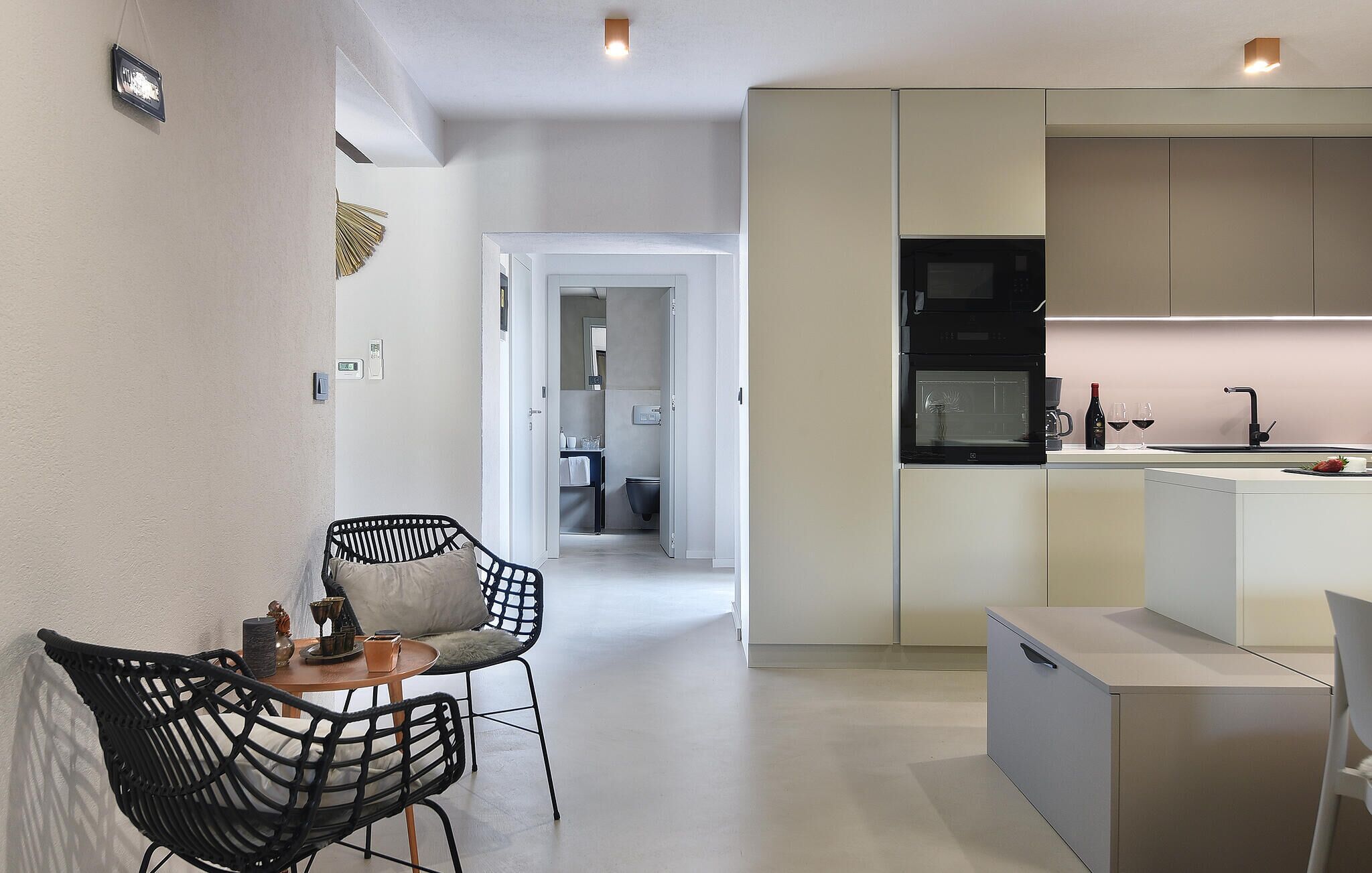 Eine moderne Küche mit Mikrowelle, Backofen und Spüle. Ein Essbereich mit Tisch und Stühlen ist ebenfalls vorhanden.
