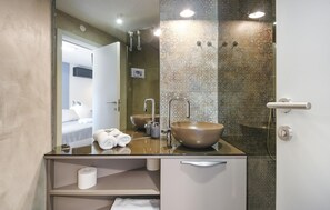 Une salle de bain moderne avec un grand miroir, une baignoire sur pieds et des toilettes.