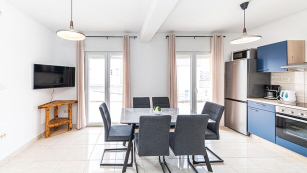 Ett modernt kök med en inbyggd ugn, en kaffebryggare och en mikrovågsugn.