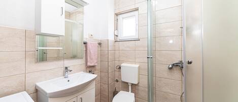 A bathroom with a sink, toilet, and shower.