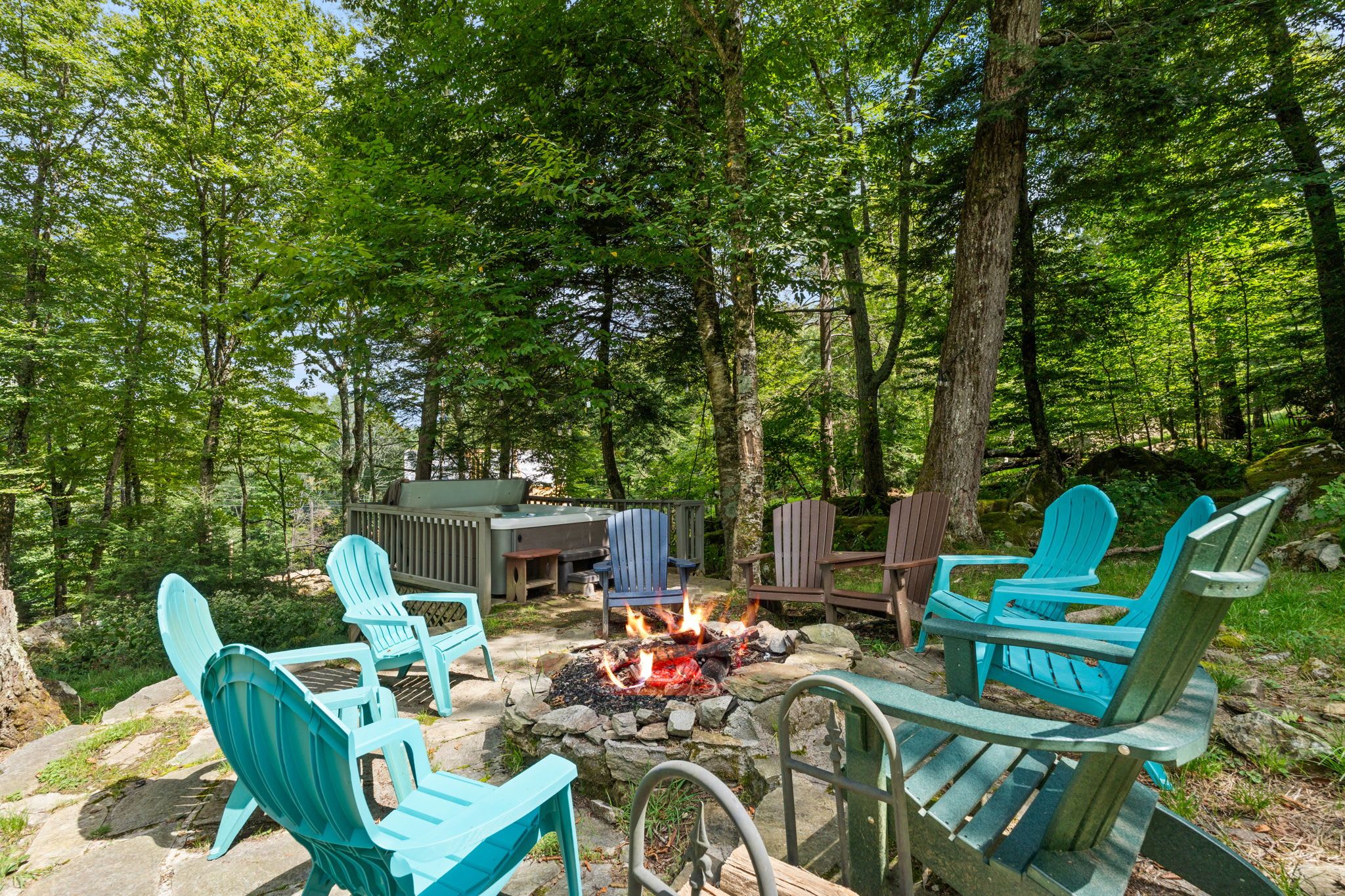 Un espace extérieur aménagé avec des chaises Adirondack et un foyer.