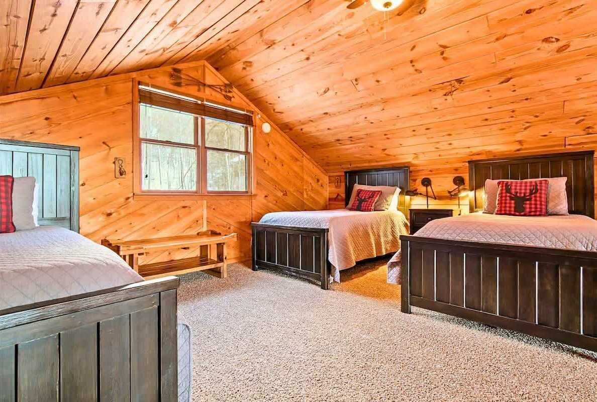 Una cabaña con dos dormitorios, cada uno con cama y mesita de noche.