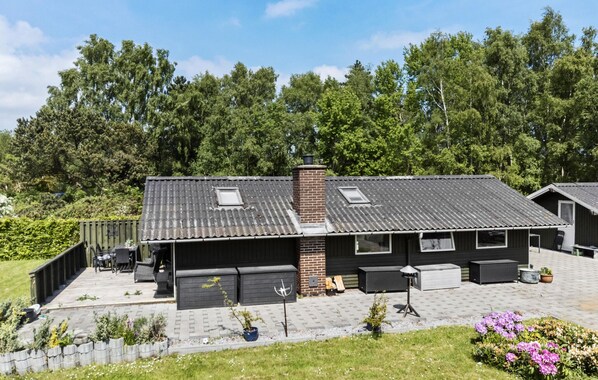 Et moderne hus med garage, overdækket terrasse og have.
