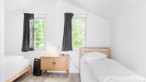 A small, well-lit room with two beds, a desk, and a window with curtains. - 3 bedroom beautiful home in Væggerløse (Væggerløse)