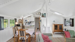 A cozy, well-lit room with a dining table, chairs, a sofa, and a cabinet. - 3 bedroom beautiful home in Væggerløse (Væggerløse)