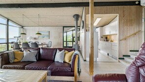 Ein modernes Wohnzimmer mit Ledersofa, Essbereich und Küche.