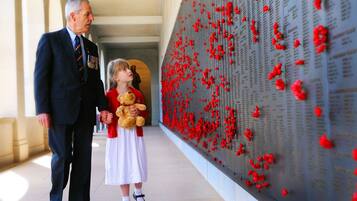 Um memorial com flores vermelhas e nomes gravados.