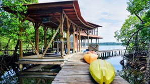 Une jetée en bois menant à une structure abritée d’où l’on peut admirer le paysage aquatique.