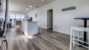 Une cuisine moderne dotée d’un îlot central, d’un éclairage suspendu et offrant une vue sur la plage de Key Colony.