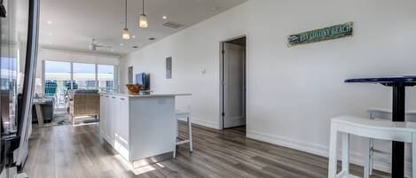 A modern kitchen with a central island, pendant lighting, and a view of Key Colony Beach.