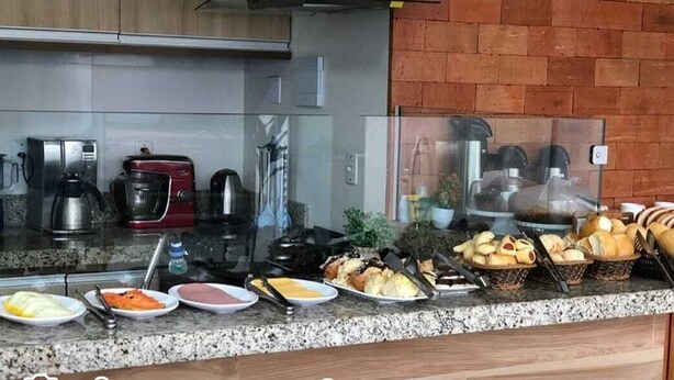 Balcão de buffet com diversos alimentos e utensílios de cozinha.