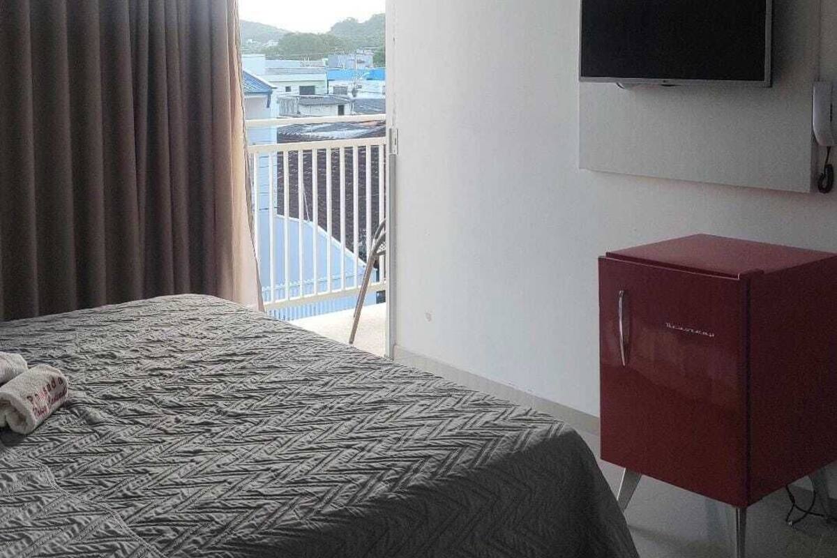 Ein Hotelzimmer mit einem Bett, einem Fernseher und einem roten Schrank.