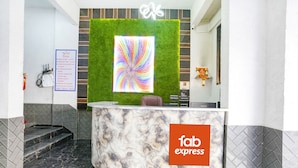 Una reception con una parete verde e un quadro astratto dai colori vivaci.
