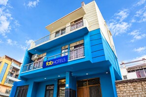 A multi-story building with a prominent 'fabHOTELS' sign, balconies, and a clear sky. - FabHotel Prime Residency (New Delhi)