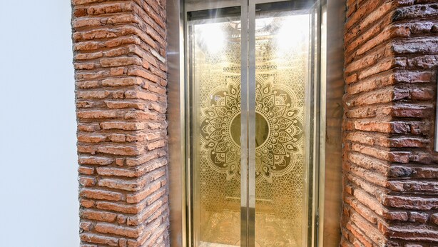 A door with intricate geometric patterns and a metallic frame. - Fabhotel Nirvana Grand By Io (Amritsar)