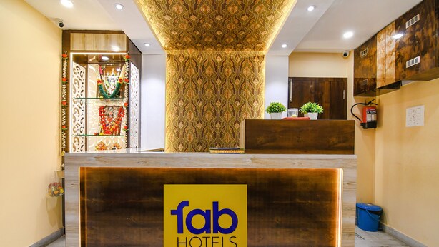 A reception desk with a 'fab hotels' sign, a patterned wall, and a wooden reception area. - Fabhotel Divine Chariot (Barasat)