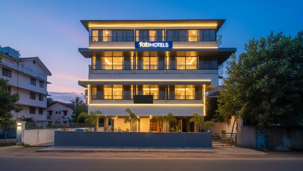 A modern multi-story hotel with a prominent 'fabHOTELS' sign, featuring balconies and large windows.