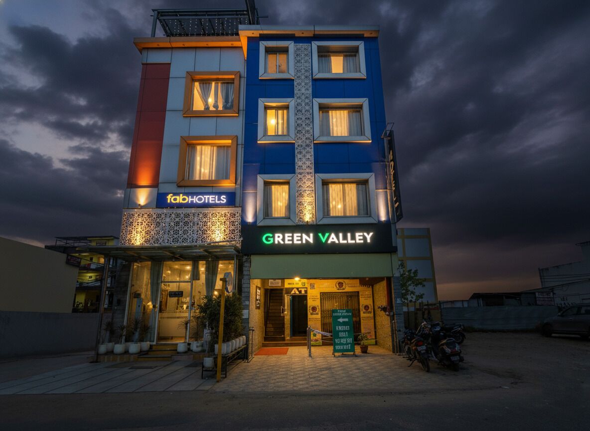 Un hotel a più piani con la segnaletica 'fabHOTELS' e 'GREEN VALLEY', caratterizzato da un design moderno, un ingresso ben visibile e un'area esterna coperta.