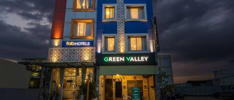 Un hotel a più piani con la segnaletica 'fabHOTELS' e 'GREEN VALLEY', caratterizzato da un design moderno, un ingresso ben visibile e un'area esterna coperta.