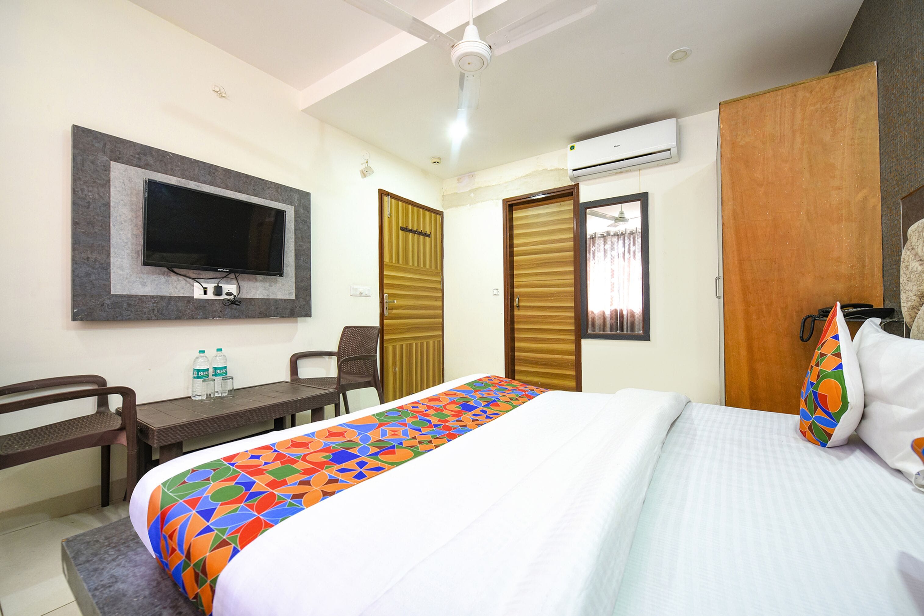 Une chambre d’hôtel équipée d’un lit, d’un bureau, d’une chaise, d’une télévision et d’un appareil de climatisation.