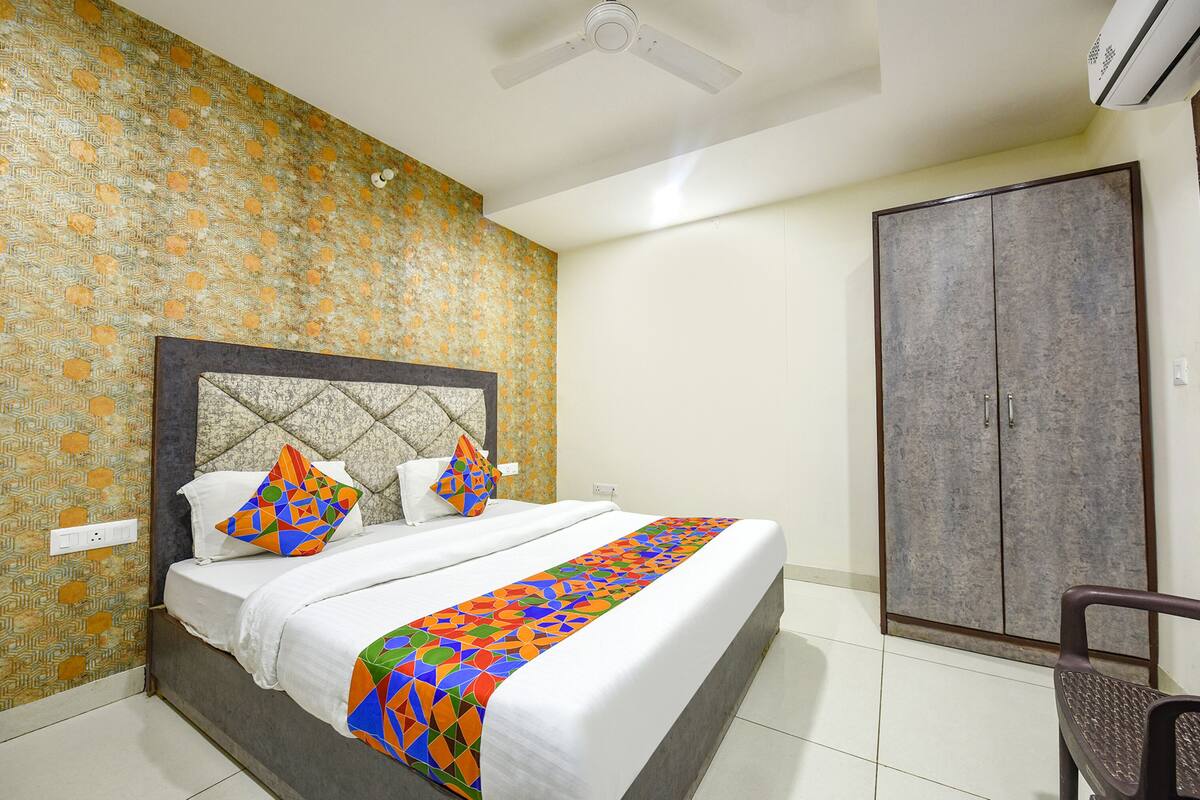A hotel room with a bed, a wardrobe, and a ceiling fan.