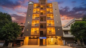 A multi-story hotel with a modern design, featuring balconies on each floor and a prominent entrance.