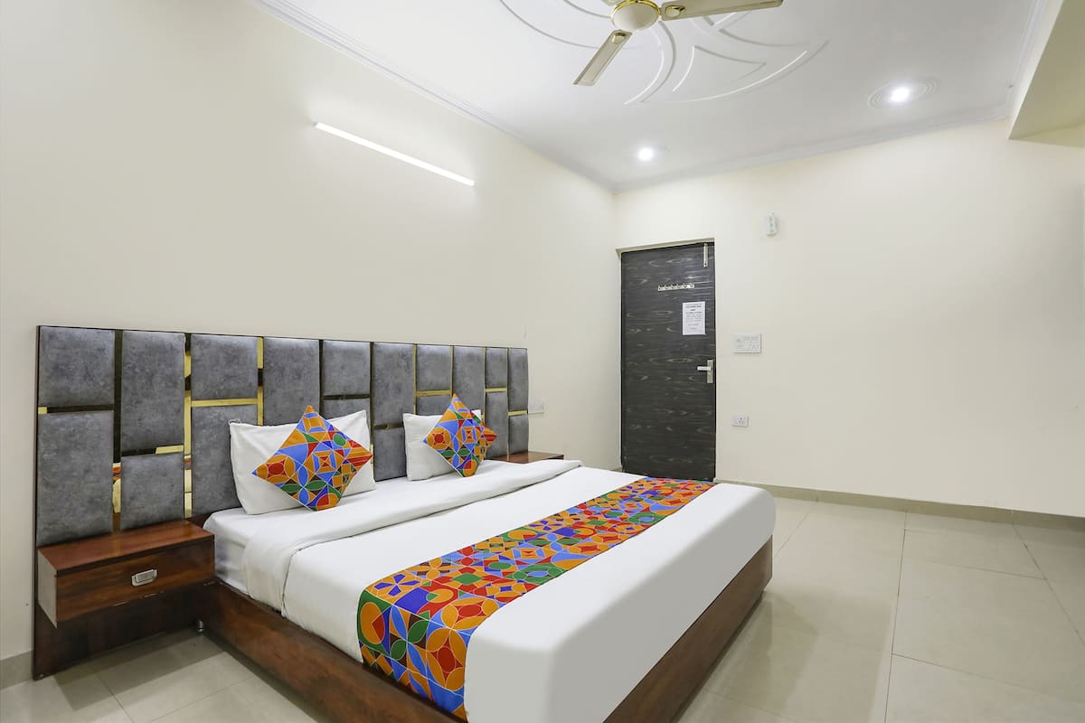 A bedroom with a bed, nightstand, and a door.