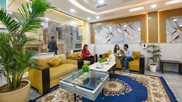 Eine moderne Lobby mit einer Couch, einem Couchtisch und Topfpflanzen.