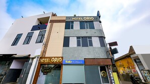 A multi-story building with a sign for "HOTEL ORIO" and "Tab Hotels" on the ground floor.