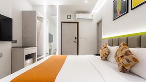 A modern hotel room with a bed, a television, a wardrobe, and a door. - FabHotel Orange Oasis (Bhopal)