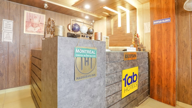 Una mesa de recepción con carteles que indican 'Montreal Hotel Mâdhuban Inn' y 'fab hotels'.