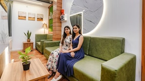 A modern interior with a green sofa, a wooden coffee table, and a potted plant. - Fabhotel Max (Vadodara)