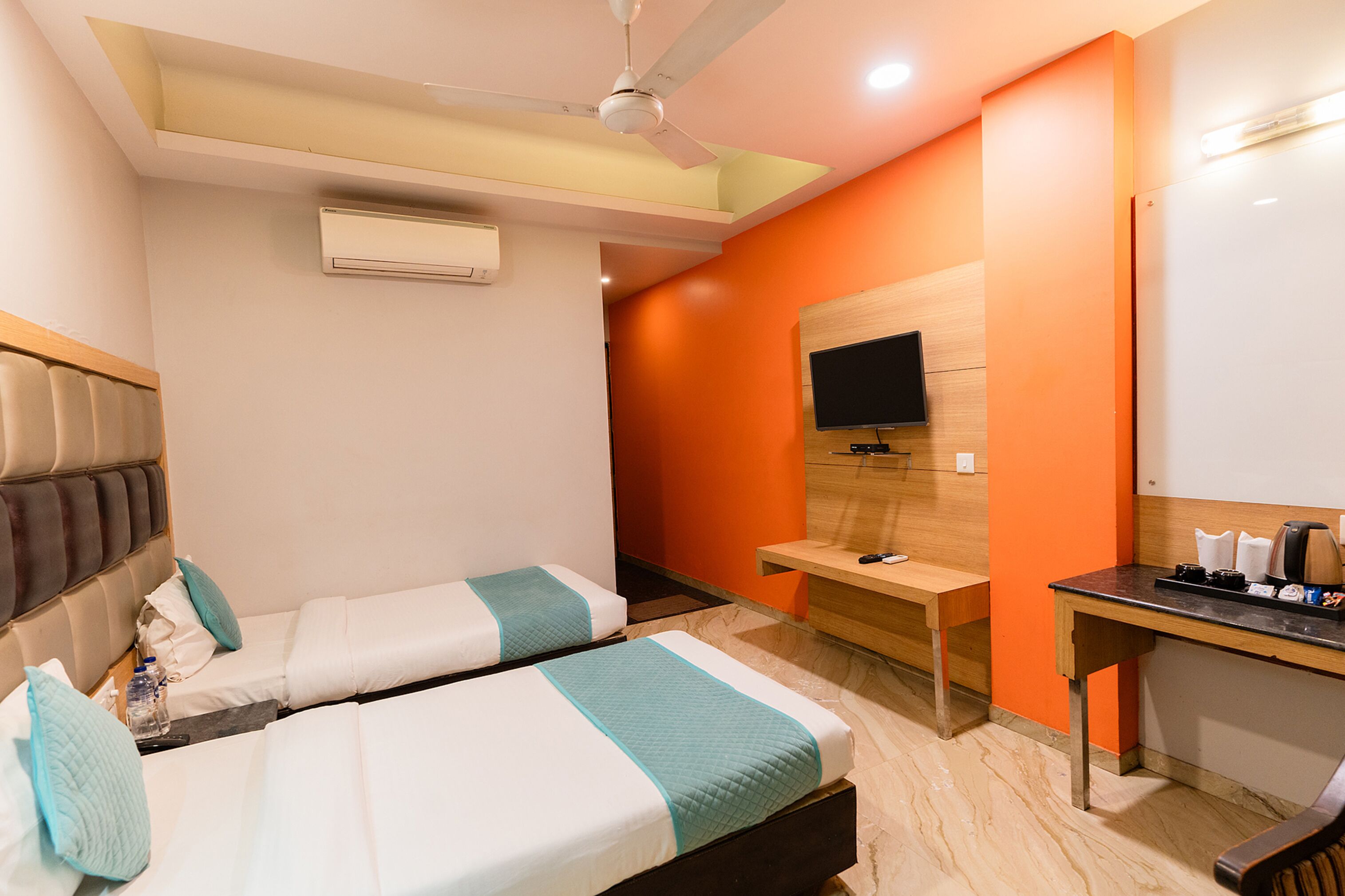 Une chambre d’hôtel avec deux lits, un bureau, une télévision et un appareil de climatisation.